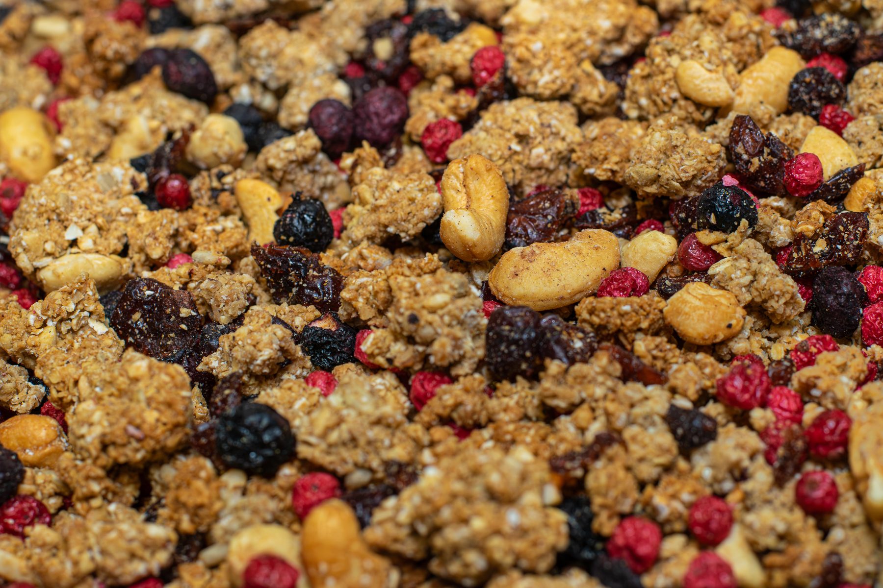 Makro granola s lesným ovocím a orechami — chrumkavé zhluky zblízka
