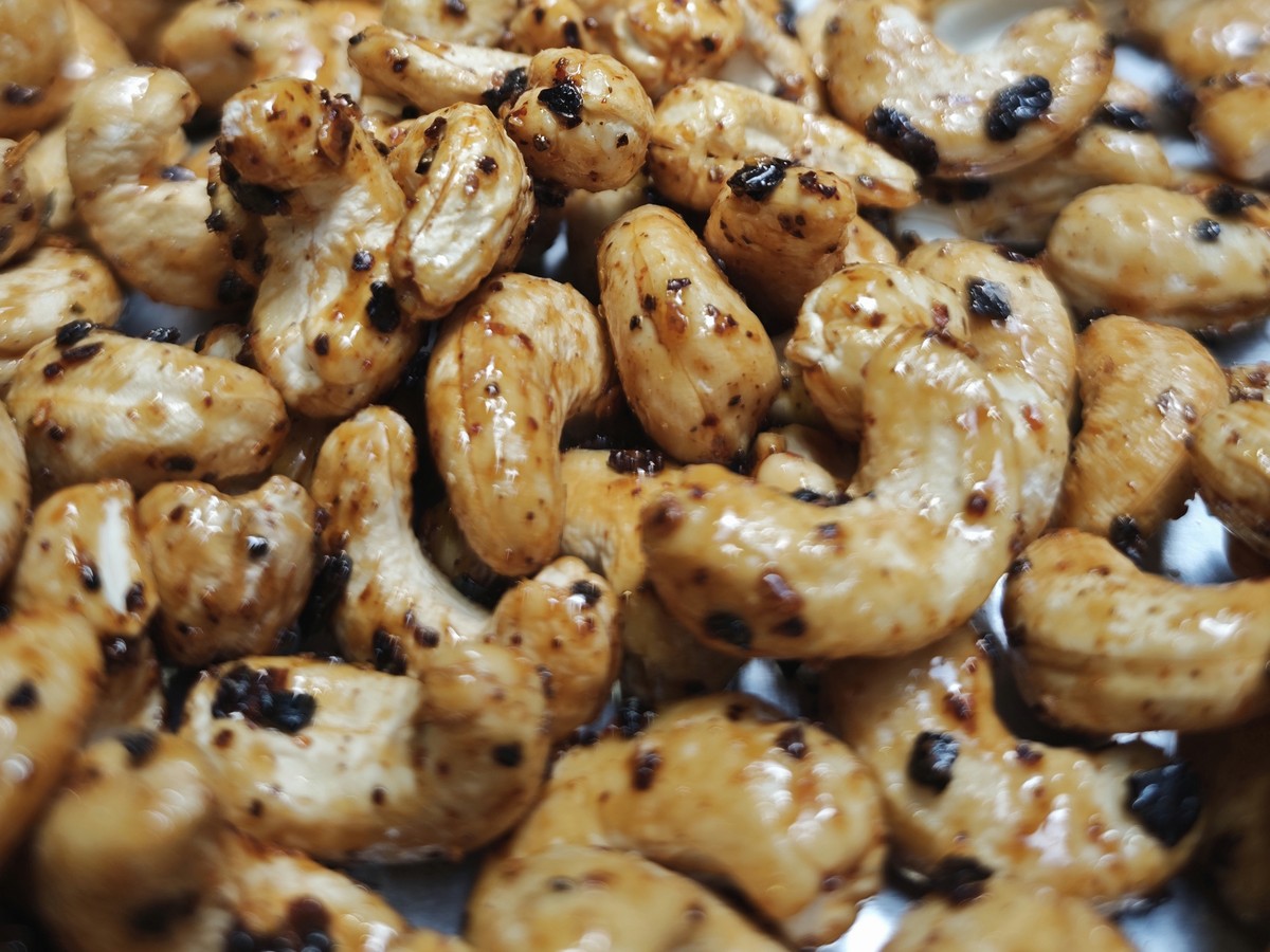 Kešu med a chipotle zblízka, lesk medovej glazúry a kúsky chipotle